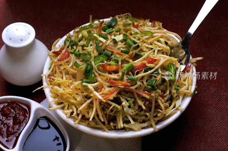 Schezwan Noodles or vegetable Hakka Noodles, or chow mein is a popular Indo-Chinese recipes, served in a bowl, Stir-fried noodles.